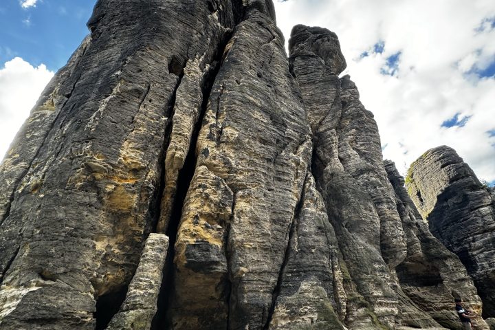 Tall rock formations under a blue sky with clouds.