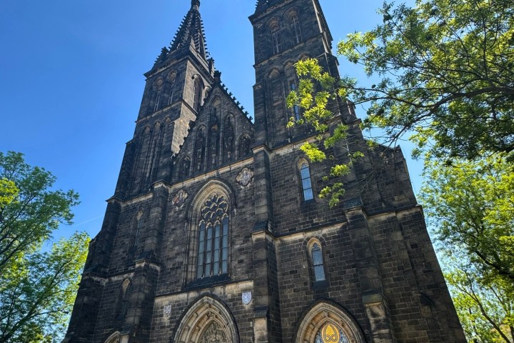 A Gothic-style church with two tall spires, seen on a sunny day.