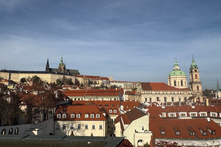Cityscape with red-roofed buildings and a cathedral under a clear sky.