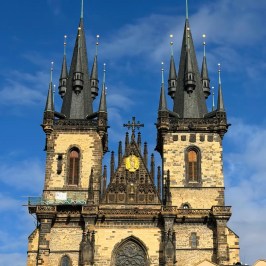 Gothic church with two tall spires against a blue sky.