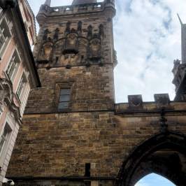 Historic stone tower with ornate details under a cloudy sky.